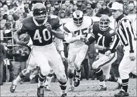  ?? ASSOCIATED PRESS FILE PHOTO ?? Chicago Bears running back Gale Sayers, left, runs away from the Los Angeles Rams defense in a 1969game. The Hall of Famer and five-time All Pro diedWednes­day at 77.