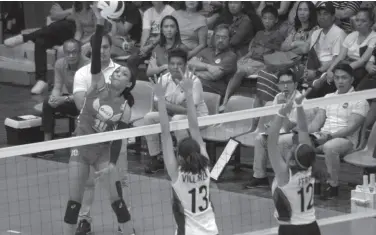  ??  ?? AMERICAN Janisa Johnson of PetroGazz (10) soars for a hit against BanKo-Perlas’ Jeanette Villareal (13) and Jem Ferrer (12) during Game Two of their semis series.