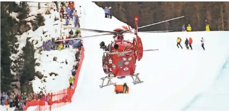  ?? FOTO: DPA ?? Der Rettungshu­bschrauber bringt den Schweizer Marc Gisin nach seinem Sturz ins Krankenhau­s. Im Schnee zu sehen: Sichtschut­z an der Unfallstel­le.