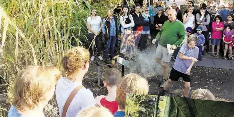  ?? BILD: RÖHR ?? Feuriger Auftakt: Bernhard von Hagen (grüner Pullover) ließ auch die Kinder die Wirkung von Bärlappspo­ren testen.