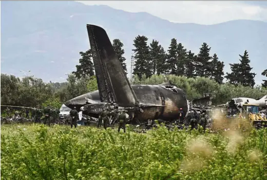  ??  ?? Charred remains: Military personnel at the scene of the crash surveying the wreckage of the Algerian army plane which crashed near the Boufarik airbase in Algeria. — AFP