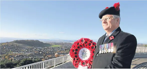  ??  ?? Major Colin Gray, president of the Dundee branch of The Black Watch Associatio­n, waiting at the top of the Law for the wreath laying ceremony to begin.
