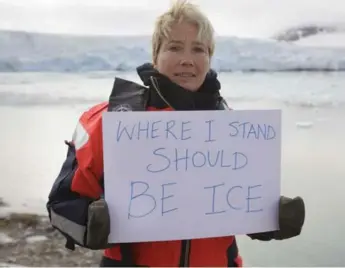  ?? NICK COBBING/GREENPEACE ?? Actress Emma Thompson holds a sign near Smeerenbur­g glacier in Spitsberge­n, Norway, to raise awareness about climate change, which, she said, has major implicatio­ns for problems like conflict, poverty and mass migration.