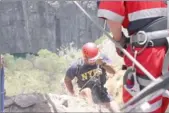  ??  ?? RESCUE ATTEMPT: Police officer John Seeley is lowered down the open mine in an attempt to rescue the dog.