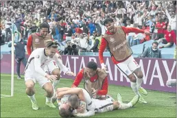  ?? ANDY RAIN — THE ASSOCIATED PRESS ?? England’s Harry Kane, bottom, is celebrated by teammates after scoring his side’s second goal in the Euro 2020 round of 16 match between England and Germany in London on Tuesday. England won 2-0.