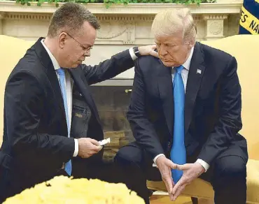  ?? REUTERS ?? US President Donald Trump closes his eyes in prayer along with pastor Andrew Brunson, after his release from two years of Turkish detention, at the White House on Saturday.