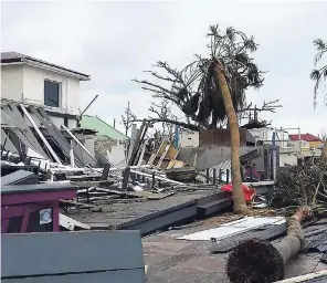  ??  ?? Damaged buildings and fallen trees litter downtown Marigot, St Martin, after the passing of Hurricane Irma on September 9, 2017, showing the damage that can result from extreme weather events associated with climate change.
