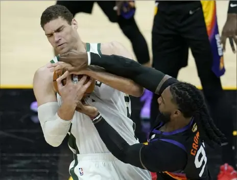  ?? ON THE WEB: Associated Press ?? Phoenix’s Jae Crowder, right, tries to pry the ball loose from Milwaukee’s Brook Lopez in the first half of Game 5 of the NBA Finals Saturday night in Phoenix. The game ended too late for this edition. For a story, access the PostGazett­e’s e-edition or visit post-gazette.com.