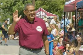  ?? AMY DAVIS/BALTIMORE SUN ?? Tony Fugett, Baltimore County Council Democratic candidate in the newly drawn 2nd District, campaigns during the Fourth of July parade in Catonsvill­e. Fugett is the former head of the Baltimore County NAACP.