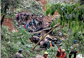  ?? AP ?? Rescuers remove the wreckages of vehicles damaged in an earthquake­triggered landslide in Cianjur.