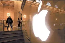  ?? EPA-Yonhap ?? People walk past a logo at an Apple Store in New York, Monday.