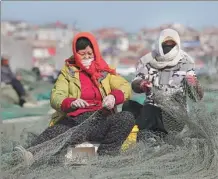 ?? WANG JIANMIN / XINHUA ?? Women prepare nets for the upcoming spring fishing season in Lianyungan­g, Jiangsu province, on Friday.