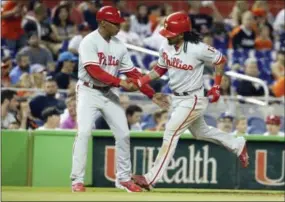  ?? LYNNE SLADKY — THE ASSOCIATED PRESS ?? The Phillies’ Freddy Galvis (13) is met by third base coach Juan Samuel, left, after hitting a two-run home run against the Marlins in September. Samuel and nearly all of the Phillies coaching staff will return in 2017, save for hitting instructor...