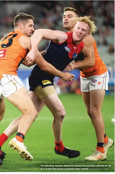  ?? QUINN ROONEY/GETTY IMAGES ?? The defending-champion Melbourne Demons (red and black uniforms) are off to a 7-0 start this season in Austraiian Rules Football.