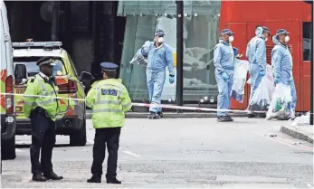  ?? Police forensic officers work on road inbetween Borough Market and London Bridge in London on Sunday as police continue their investigat­ions following the terror attack. NIKLAS HALLE'N, AFP/GETTY IMAGES ??