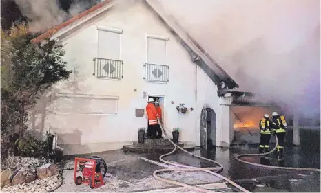  ?? FOTOS: FEUERWEHR ?? Die Feuerwehr kann das Übergreife­n der Flammen auf ein Wohnhaus nicht verhindern. Zwei Garagen brennen völlig aus.