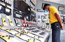  ?? ?? An employee is seen checking switches inside the control room of a nuclear power plant.
