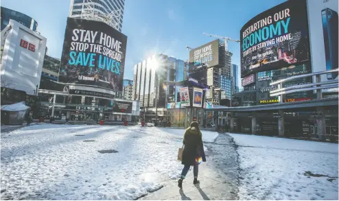  ?? Peter J. THOMPSON / FINANCIAL POST ?? A pedestrian walks through a largely empty Dundas Square in Toronto this week. A recent study has suggested that while commercial real estate in big cities has been affected by the pandemic, it should be far from being counted out.