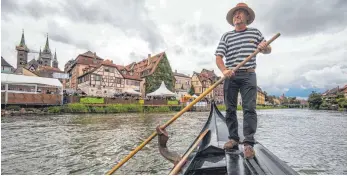  ?? FOTO: DPA ?? Der Bamberger Gondolieri Jürgen Riegel rudert über die Regnitz durch die Altstadt von Bamberg.