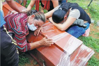  ?? JAIME SALDARRIAG­A / REUTERS ?? Women cry next to a coffin in a cemetery after flooding and mudslides caused by heavy rain led several rivers to overflow, pushing sediment and rocks into buildings and roads in Mocoa, Colombia.