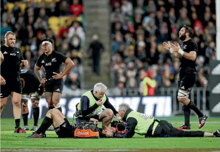  ?? GETTY IMAGES ?? In a scene resembling a battlegrou­nd, All Blacks pivot Aaron Cruden receives treatment after being crushed in a tackle last night.