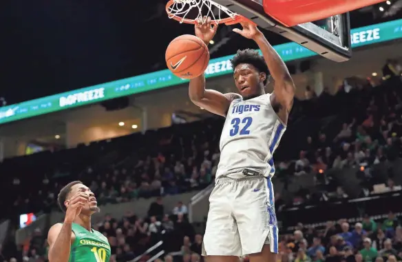  ?? JOE RONDONE/COMMERCIAL APPEAL ?? Memphis center James Wiseman, right,dunks the ball over Oregon forward Shakur Juiston on Nov. 12, 2019.