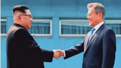  ?? POOL PHOTO FROM AFP/GETTY IMAGES ?? North Korea’s Kim Jong Un, left, and South Korea’s Moon Jae-in meet April 27 at the border that divides their countries.