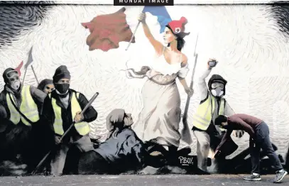  ?? |
Reuters ?? A PEDESTRIAN examines a mural paying homage to the Yellow Vest protesters in Paris, recently.