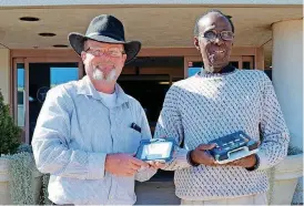  ?? [PHOTO PROVIDED] ?? Oklahoma Library for the Blind and Physically Handicappe­d Director Kevin Treese, left, and electronic technician Karl Williams display the cartridge case and player used by nearly 5,000 library patrons who listen to free audio books every week.