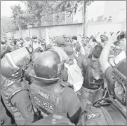  ??  ?? ▲ Elementos de la Secretaría de Seguridad capitalina retiran a ex policías federales de la avenida Constituye­ntes. Foto Víctor
Camacho