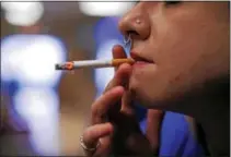  ?? GENE J. PUSKAR / THE ASSOCIATED PRESS FILE ?? Store manager Stephanie Hunt smokes a Marlboro cigarette while posing for photos at a Smoker Friendly shop in Pittsburgh.