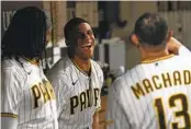  ?? GREGORY BULL AP ?? Padres’ Juan Soto, center, jokes with teammates Manny Machado and Josh Bell on Wednesday.