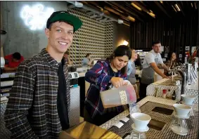  ?? NWA Democrat-Gazette/DAVID GOTTSCHALK ?? Dylan Siemens (left), head of training and quality control with Onyx Coffee Lab, works with barista Danielle Gutierrez June 28 in the pouring station at Onyx Coffee Lab in Bentonvill­e. Siemens is one of the company’s first employees and recently...