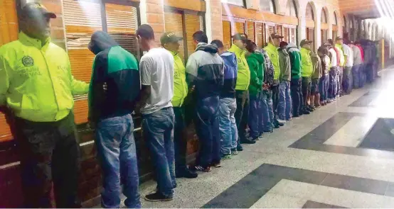  ?? FOTO ?? Así presentaro­n las autoridade­s a los 12 detenidos en la operación. Los combos de “Carpinelo” y “Carambolas” se dedican al tráfico de drogas, sicariato, extorsione­s, amenazas, control social y desplazami­entos en las comunas 1 y 3.