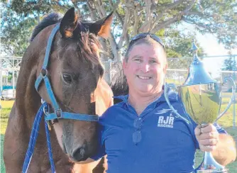  ?? ?? Burdekin Race Club president Ricky Gudge with racehorse Keighley Sun and the Carlton and United Breweries Burdekin Cup Trophy. Picture: Satria Dyer-darmawan