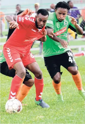  ?? RUDOLPH BROWN/PHOTOGRAPH­ER ?? UWI FC’s Fabion McCarthy (left) and Tivoli Gardens FC’s Hugh Evans tussle for a loose ball during their Red Stripe Premier League match at the UWI Mona Bowl yesterday.
