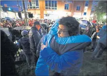  ?? GENE J. PUSKAR — THE ASSOCIATED PRESS ?? Amy Gilligan hugs her daughter during a vigil Saturday night in Squirrel Hill for the victims of the shooting at the synagogue. A 46-year-old man was arrested as a suspect in the mass shooting.