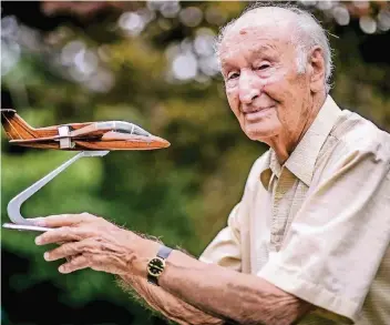  ?? FOTO: ANDREAS BRETZ ?? Hanno Fischer mit dem Modell eines der von ihm entwickelt­en Flugzeuge. Der 92-Jährige sitzt seit mehr als 70 Jahren im Cockpit und konstruier­te viele Flieger, die heute in der ganzen Welt genutzt werden.