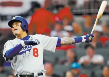  ?? John Bazemore ?? The Associated Press Manny Machado follows through on a three-run homer in the seventh inning of the Dodgers’ series-clinching6-2 victory over the Braves on Monday at Suntrust Park. He also hit an RBI double in the first.