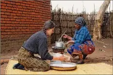  ?? Roy Nkosi / Associated Press ?? Cameron Beach, left, sieves maize flour as she helps prepare a meal, in Dedza, near Lilongwe, Malawi on July 23.