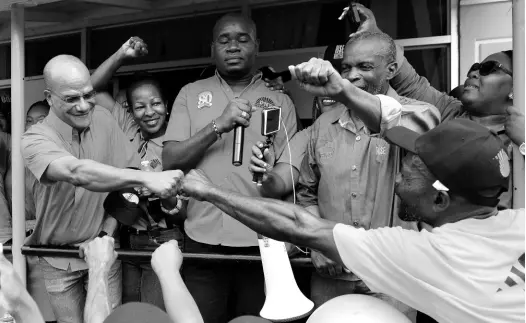  ??  ?? Peter Bunting (left) hails supporters during Friday’s PNP presidenti­al nomination­s.