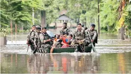  ??  ?? Army soldiers rescuing people from the flood affected village Debasatra at Jokhalaban­dha in Nagaon district of Assam on Sunday