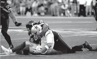  ?? Associated Press ?? Dallas Cowboys quarterbac­k Tony Romo is tackled by Seattle Seahawks defensive end Cliff Avril during the first half of a preseason game Thursday in Seattle.