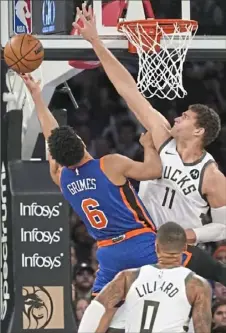  ?? Peter K. Afriyie/Associated Press ?? Milwaukee’s Brook Lopez, right, challenges the shot of New York’s Quentin Grimes Saturday in New York.