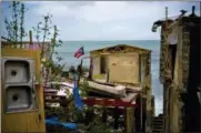  ?? RAMON ESPINOSA — THE ASSOCIATED PRESS ?? A Puerto Rican national flag is mounted on debris of a damaged home in the aftermath of Hurricane Maria in 2017in the seaside slum La Perla, San Juan, Puerto Rico. An independen­t investigat­ion ordered by Puerto Rico’s government estimates that nearly 3,000people died as a result of Hurricane Maria.