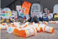  ?? PATRICK SEMANSKY/ASSOCIATED PRESS ?? Containers depicting OxyContin bottles lie on the ground in front of the Department of Health and Human Services headquarte­rs in Washington during a protest in April.