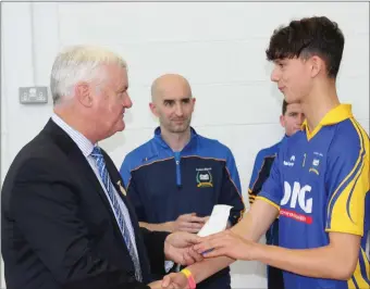  ??  ?? Zack Mannas, captain of the Colaiste Mhuire U16 Football team, who won the County Schools Football Championsh­ip 2017 being presented with his medal by Aogan O’ Fearghail, President of the GAA.