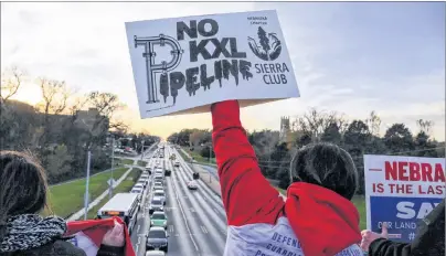  ?? CP PHOTO ?? Opponents of the Keystone XL pipeline demonstrat­e on the Dodge Street pedestrian bridge during rush hour in Omaha, Neb., on Nov. 1, 2017. A federal judge in Montana has blocked constructi­on of the $8-billion Keystone XL pipeline to allow more time to study the project’s potential environmen­tal impact.