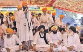  ?? GURPREET SINGH/HT ?? ■ Sikh preacher Baljit Singh Daduwal addresses the gathering as AAP rebel MLA Sukhpal Khaira and Lok Insaaf Party MLA Simarjeet Bains (3rd and 2nd from right) look on in Bargari.