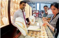  ??  ?? A family buying gold at a shop in Sharjah.